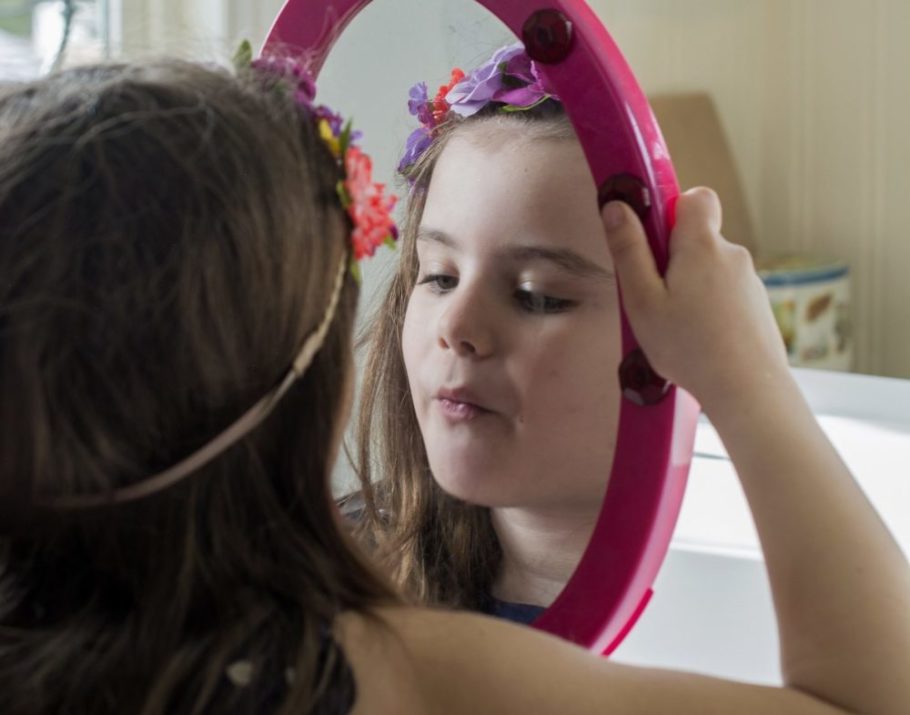 Little girl looking in mirror